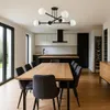 A modern dining room and kitchen area with a wooden table and chairs, and a sleek kitchen setup. Náhled obrázku produktu