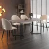 A dining table and chairs set in a modern dining room with a large window and blinds. Produktbild-Vorschau