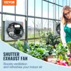 A woman tending to plants in a greenhouse with an exhaust fan mounted on the wall. Podgląd zdjęcia produktu