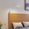 A white LED clip-on lamp is attached to the headboard of a bed. Produktbild-Vorschau