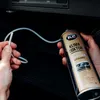Hands holding a can of K2 Klima Doctor A/C cleaner and a white tube, with the can being sprayed into a car's air vent. Anteprima dell’immagine prodotto