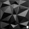 A close-up, studio shot of a black 3D wall panel with geometric facets. Produktbild-Vorschau