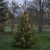 A decorated Christmas tree in an outdoor setting at dusk. Produktbild-Vorschau