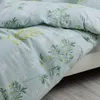 A close-up view of a light blue duvet cover with a green leaf pattern. Produktbild-Vorschau