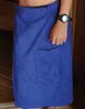 A person wearing a blue towel kilt in what appears to be a sauna or changing room. Produktbild-Vorschau