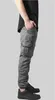 A person wearing grey cargo jogging pants and black sneakers, shown from the side. Produktbild-Vorschau