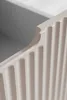 A close-up view of the fluted front of a beige cabinet. Produktbild-Vorschau