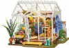 A miniature greenhouse model with various plants and furniture inside. Anteprima dell’immagine prodotto