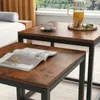 A close-up view of two nesting coffee tables with a rustic, industrial design, placed in a living room setting. Podgląd zdjęcia produktu