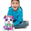 A young boy is happily playing with a purple plush dog toy. Produktbild-Vorschau