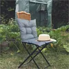 A chair with a cushion and hat in a garden setting. Podgląd zdjęcia produktu