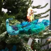 A decorative peacock ornament hangs on a Christmas tree. Produktbild-Vorschau
