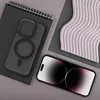 A black phone case and a smartphone are laid out on a gray surface next to a notebook and a decorative wavy object. Produktbild-Vorschau