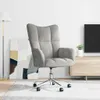 A light gray velvet armchair is shown in a room with a floor lamp and a TV stand. Náhled obrázku produktu