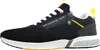 A side view of a black sneaker with white laces and yellow accents. Voir les images du produit