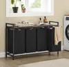 A laundry room scene with a multi-compartment laundry sorter, a washing machine, and plants on a windowsill. Produktbild-Vorschau
