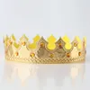 A golden crown with orange jewels on a white surface. Produktbild-Vorschau