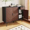 A modern sideboard with a herringbone wood grain pattern on the doors, black metal legs, and an open drawer and door revealing storage shelves inside. It is placed on a wooden floor with a rug in the foreground. Náhled obrázku produktu