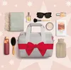 A collection of items arranged around a central duffel bag, suggesting a gift set or travel essentials. Produktbild-Vorschau