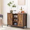 A rustic brown sideboard with sliding barn doors and black metal frame, styled with decorative items. Náhled obrázku produktu