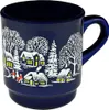 A dark blue mug with a white winter village scene printed on it. The scene depicts houses with yellow lit windows, snow-covered trees, and small figures of people. The mug is shown from a slightly elevated side angle against a white background. Náhled obrázku produktu