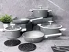 A set of grey cookware with white handles is displayed on a grey, textured surface. Podgląd zdjęcia produktu