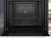 The interior of an open oven with racks visible. Produktbild-Vorschau