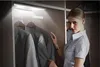A woman is looking through clothes in a closet with LED lighting. Anteprima dell’immagine prodotto