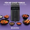 A black air fryer is shown in the center, surrounded by bowls of food, with promotional text above. Produktbild-Vorschau