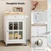 A collage of images showing the details of a white kitchen cart with a wood top. The collage includes close-ups of the rubber wood surface, magnetic door catch, smooth metal drawer slides, and round drawer knobs. The main image shows the kitchen cart with  Podgląd zdjęcia produktu