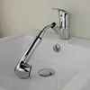 A chrome faucet with a pull-out spray head is positioned over a white sink. Produktbild-Vorschau