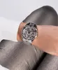 A person's wrist wearing a silver Guess watch with clear stones. Voir les images du produit