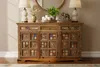 A wooden sideboard with decorative tiles and carvings, displayed in a home setting with lamps and decorative items on top. Produktbild-Vorschau