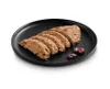 Sliced food product on a black plate with cranberries. Produktbild-Vorschau
