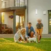 A family playing with their dog in the yard of a modern house. Produktbild-Vorschau