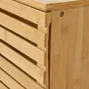 A close-up view of a bamboo cabinet, showing the slatted drawer fronts and a side panel with a screw. Podgląd zdjęcia produktu