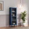 A navy blue glass-fronted cabinet stands against a wall with decorative paneling. A potted plant and pendant lights are also visible. Produktbild-Vorschau