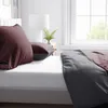 A close-up view of a bed with bedding. Produktbild-Vorschau