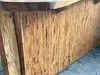 A close-up view of a wooden bar or counter with a textured surface made of vertical bamboo-like slats. Anteprima dell’immagine prodotto