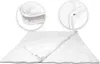A white duvet is laid out flat on a white background, with two circular close-up insets showing details of the duvet's construction. Voir les images du produit