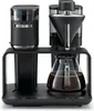 A black Melitta coffee maker with a glass carafe filled with coffee. Produktbild-Vorschau