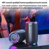 Two portable Bluetooth speakers are displayed in the foreground, with a blurred background of people dancing at a party. Produktbild-Vorschau
