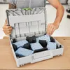 A person is holding open a gray storage case filled with blue and black sanding pads. Podgląd zdjęcia produktu