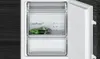 Close-up shot inside a refrigerator or freezer with an open door, showing two drawers. The top drawer contains a bag of green vegetables. Produktbild-Vorschau