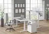 A modern office space with two height-adjustable desks, chairs, and office equipment. Podgląd zdjęcia produktu