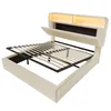 A beige upholstered bed frame with the mattress support system lifted to reveal storage space underneath. The headboard has integrated LED lighting. Náhled obrázku produktu