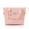 A pink duffel bag with handles and a logo is shown against a white background. Náhľad obrázku produktu