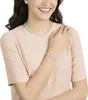 A woman wearing a pink shirt and a pearl necklace and bracelet set. Anteprima dell’immagine prodotto