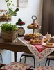A rustic kitchen scene with a wooden table laden with fresh produce and baked goods. Produktbild-Vorschau