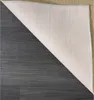 The underside of a rug is shown, folded back to reveal the flooring underneath. Produktbild-Vorschau